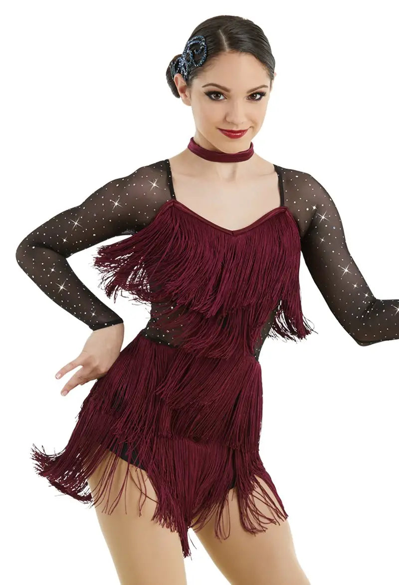 Woman wearing a burgundy fringe dress with black mesh sleeves on a white background